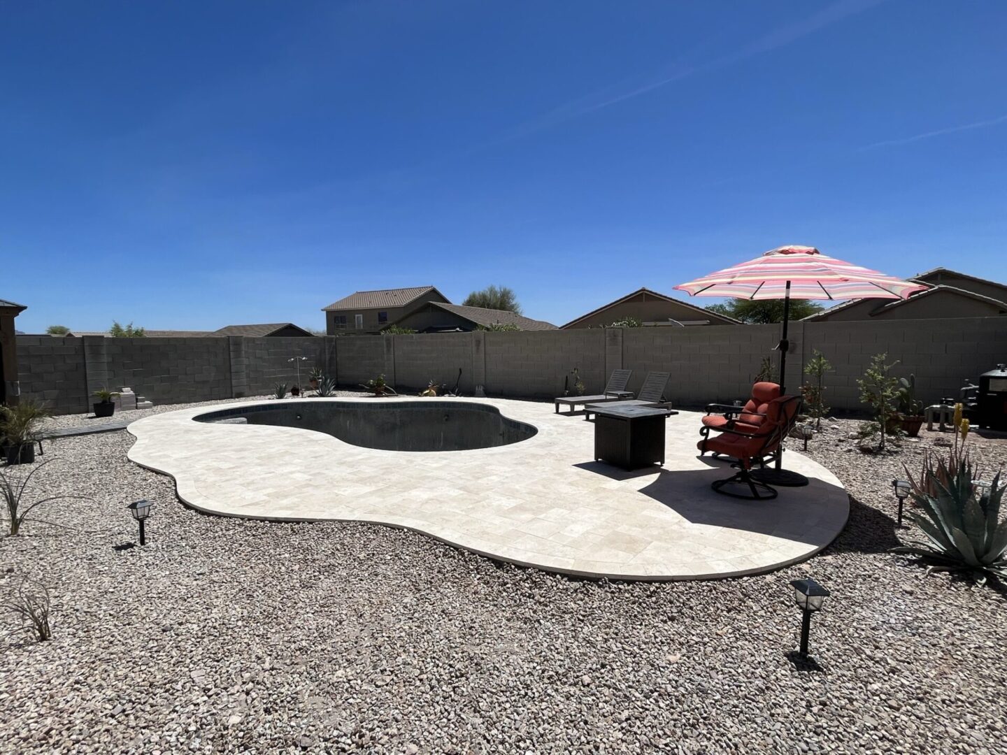 A backyard with a pool and an umbrella.